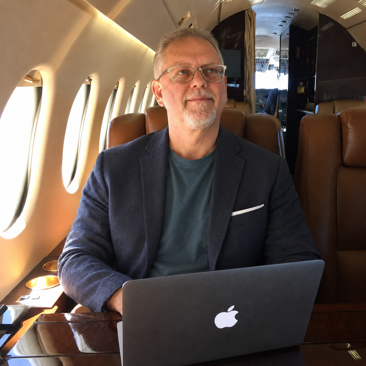 Joel Ward seated with a laptop in an aircraft cabin